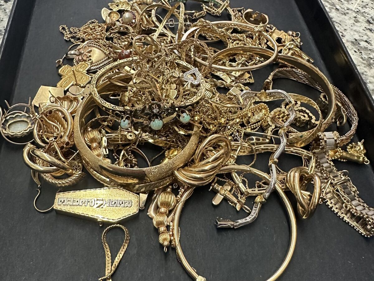 A tray piled with gold chains, rings, bracelets, and pendants brought in to sell at Legacy